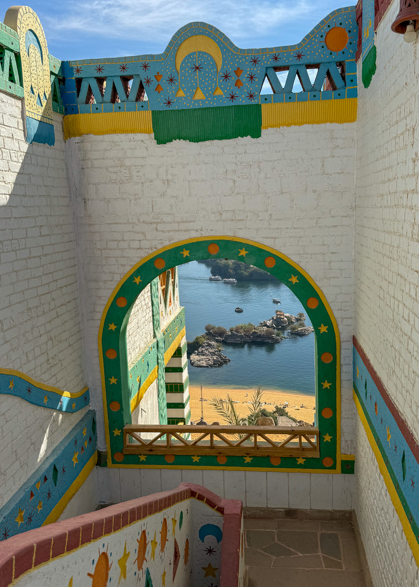 A beautifully framed view of the Nile River seen through a colorful arched window at Kato Dool in Aswan, Egypt.