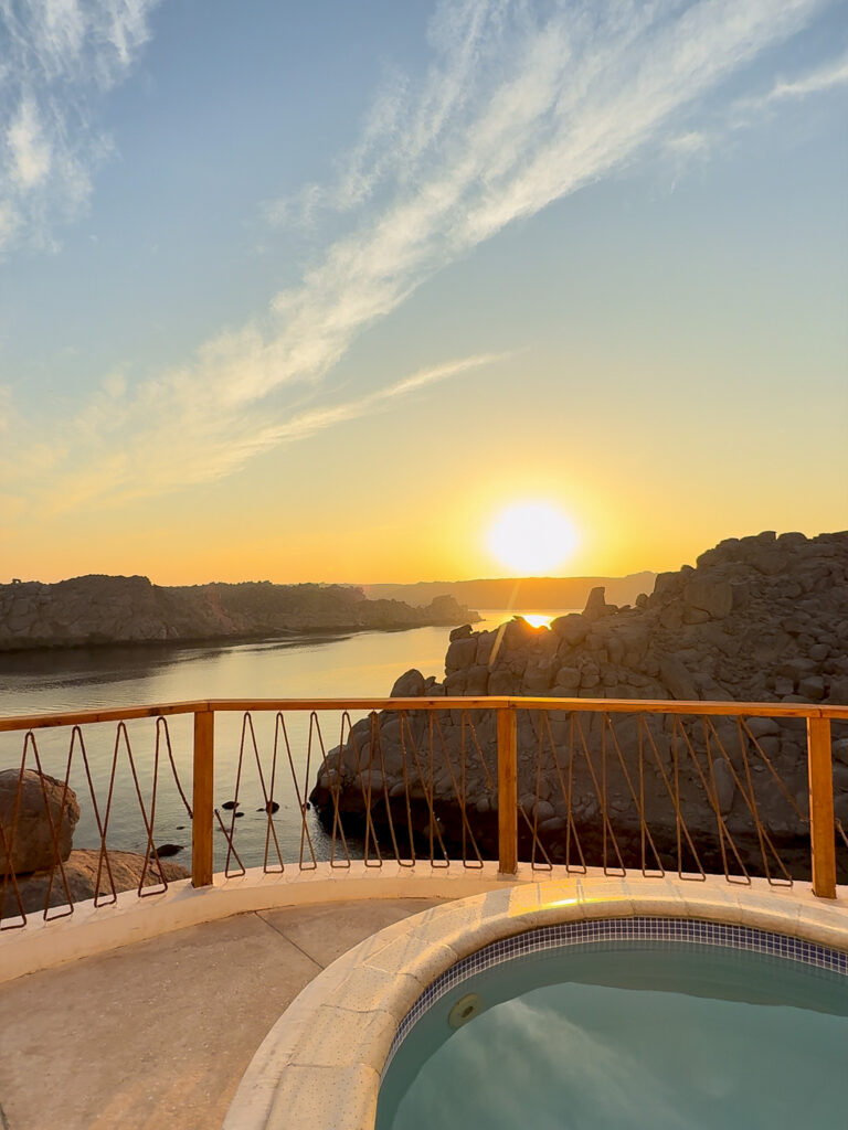 A private jacuzzi at Benben by Dhara in Aswan, overlooking the Nile with a breathtaking sunrise reflecting on the water.