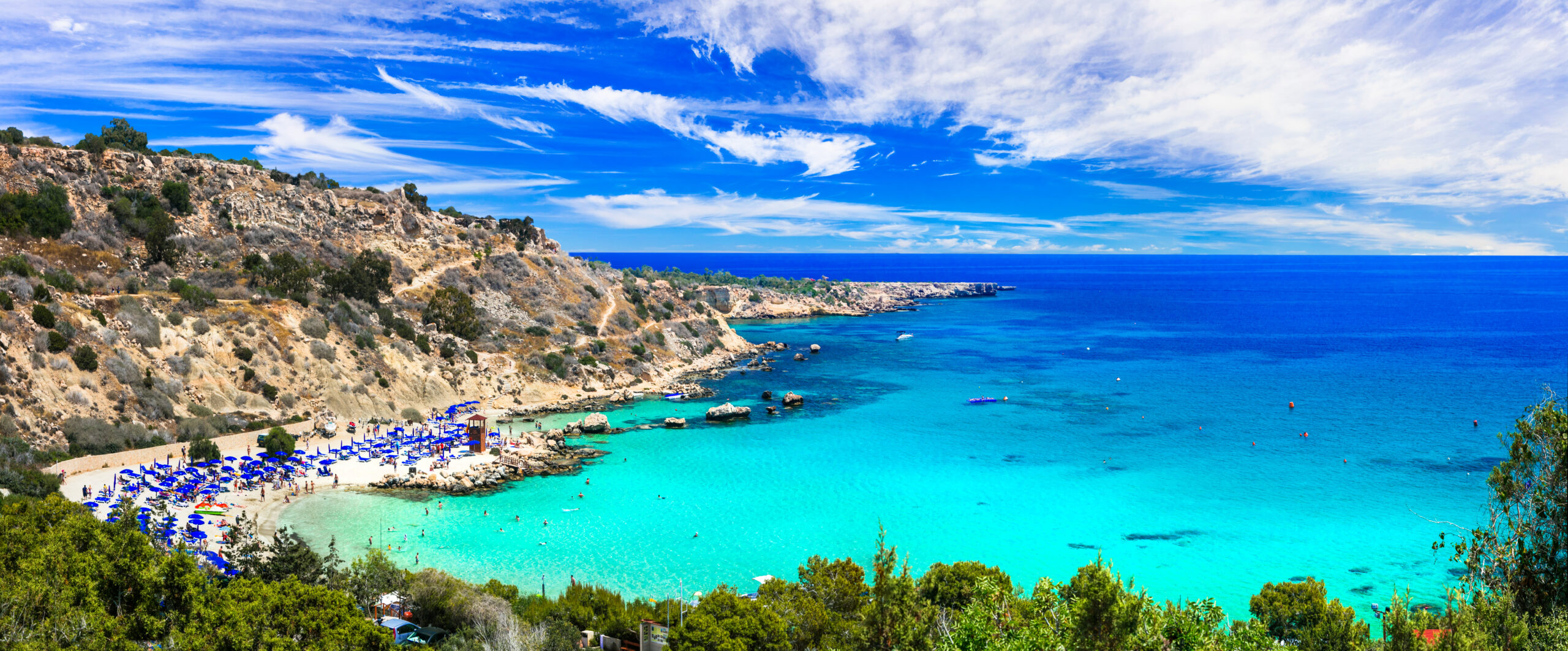 A breathtaking view of Konnos Bay in Cyprus, featuring turquoise waters, golden sand, and rugged cliffs in Cape Greko National Park.