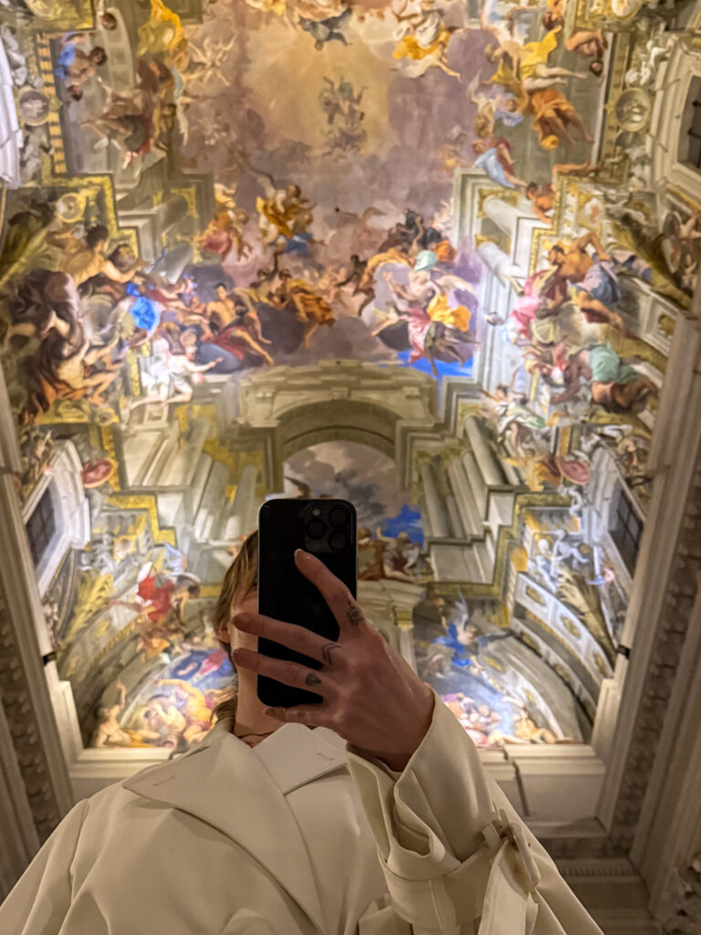 A stunning fresco ceiling at Chiesa di Sant’Ignazio in Rome, viewed from below, showcasing intricate Baroque artwork.