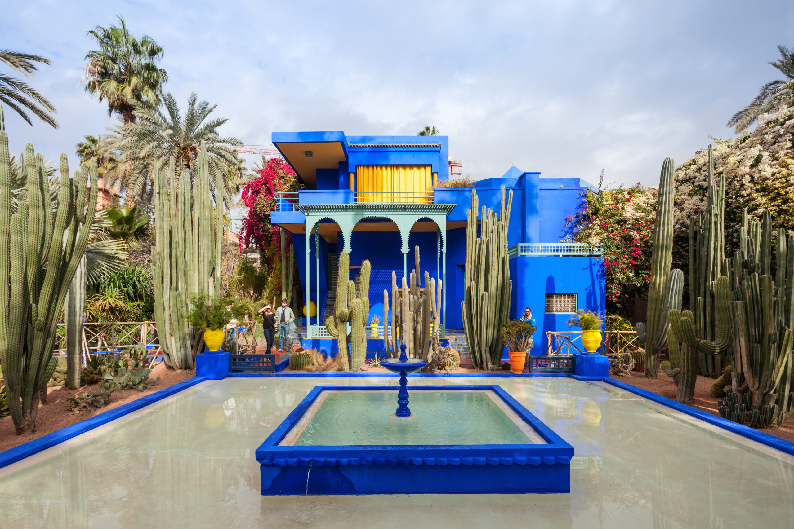 Le Jardin Majorelle in Marrakech, Morocco – vibrant blue villa surrounded by lush gardens and towering cactus plants