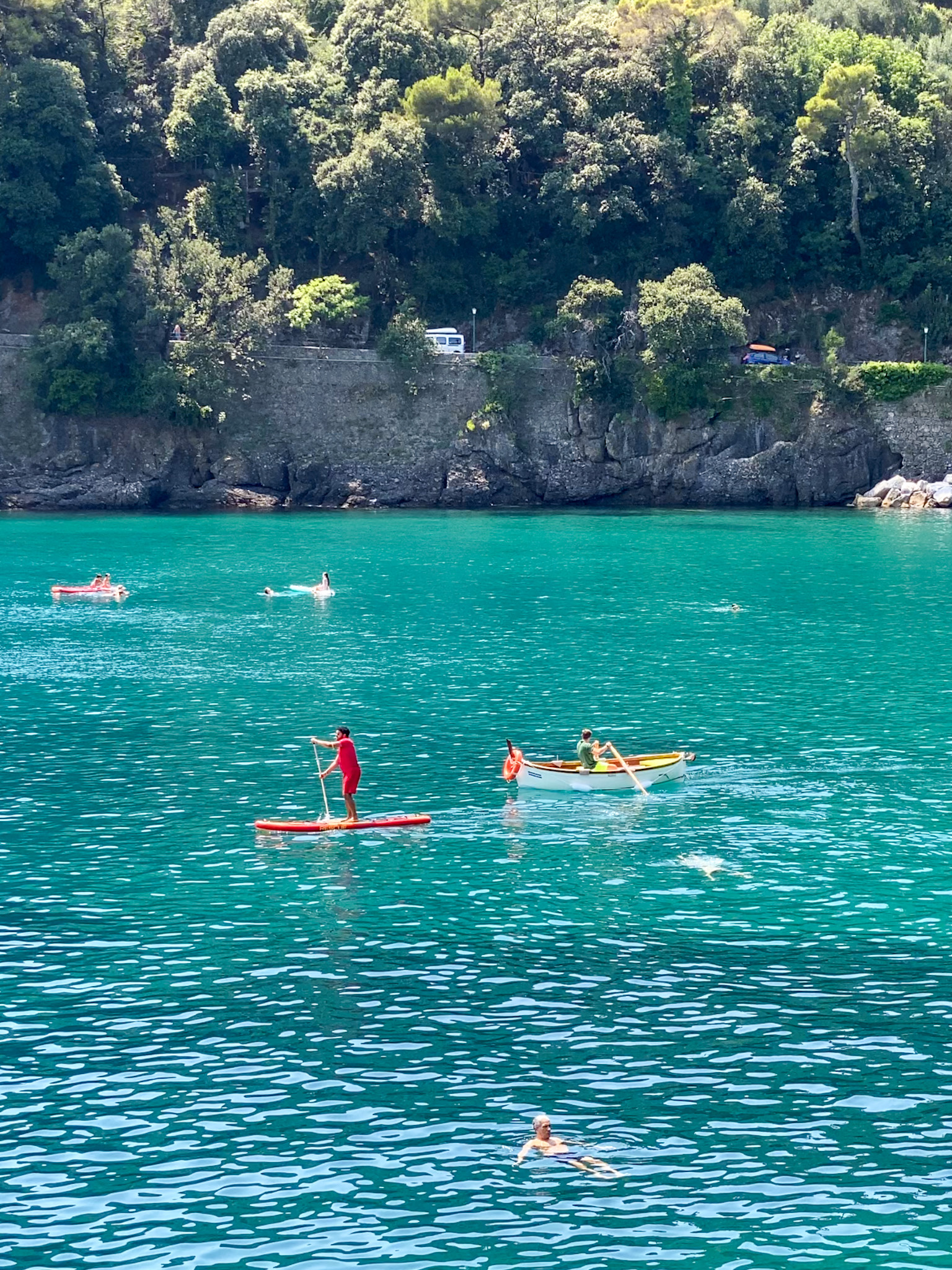 A scenic view of Paraggi Beach with its emerald-green waters and sunbeds lining the shore, located between Santa Margherita Ligure and Portofino.