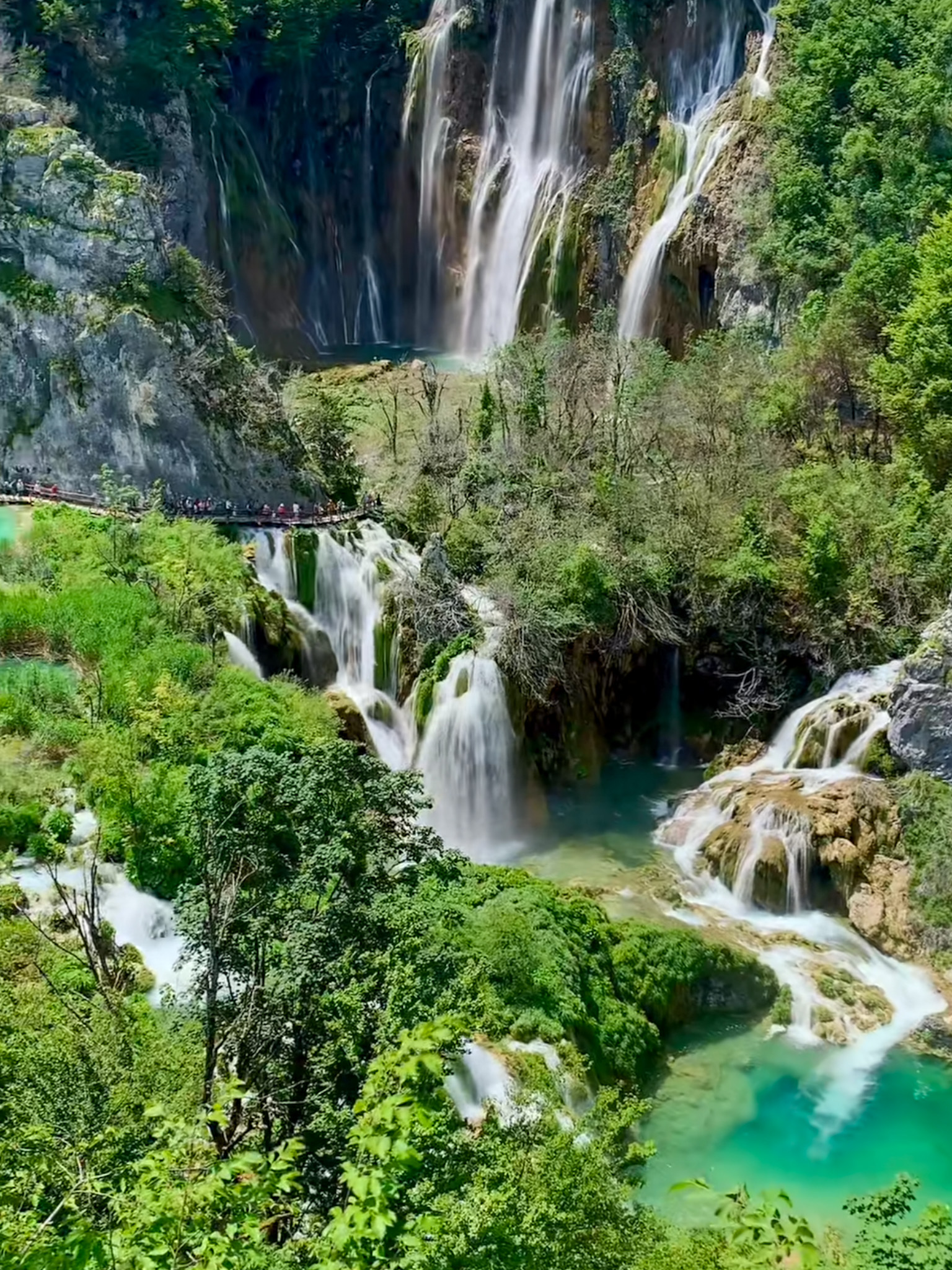 Stunning view of Plitvice Lakes National Park in Croatia, showcasing cascading waterfalls, turquoise lakes, and lush green surroundings