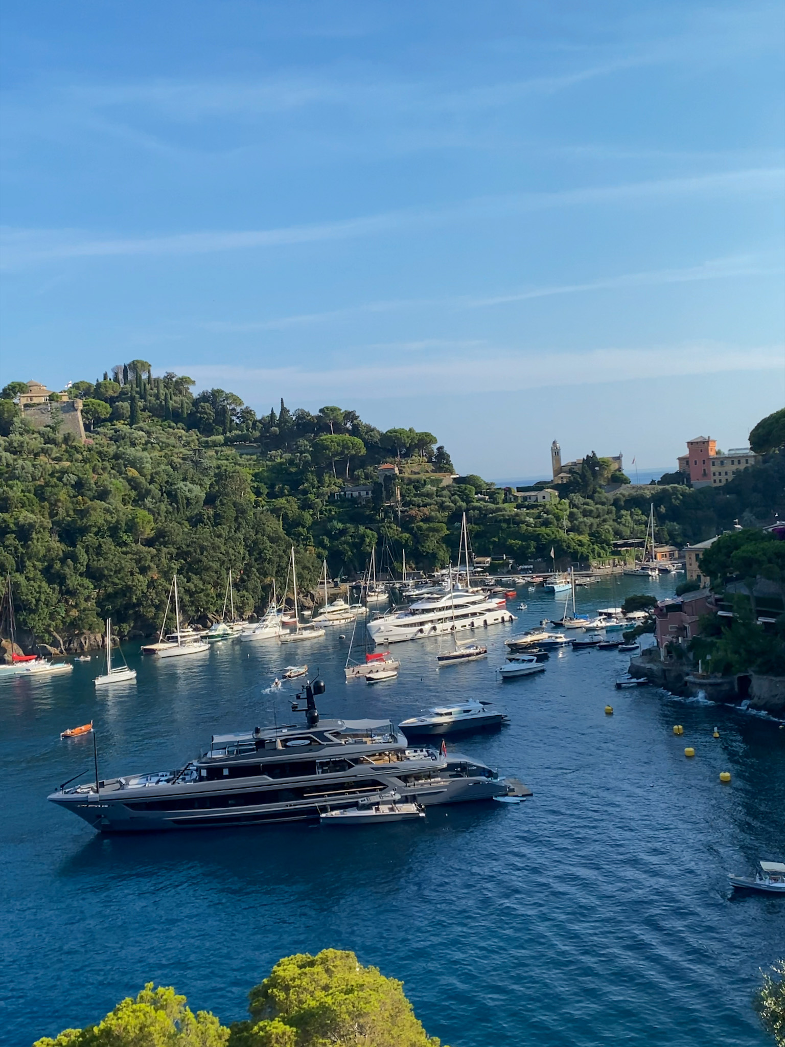 A luxury yacht anchored in Portofino’s seafront, surrounded by the stunning coastline of the Italian Riviera. The perfect setting for an exclusive sailing experience.