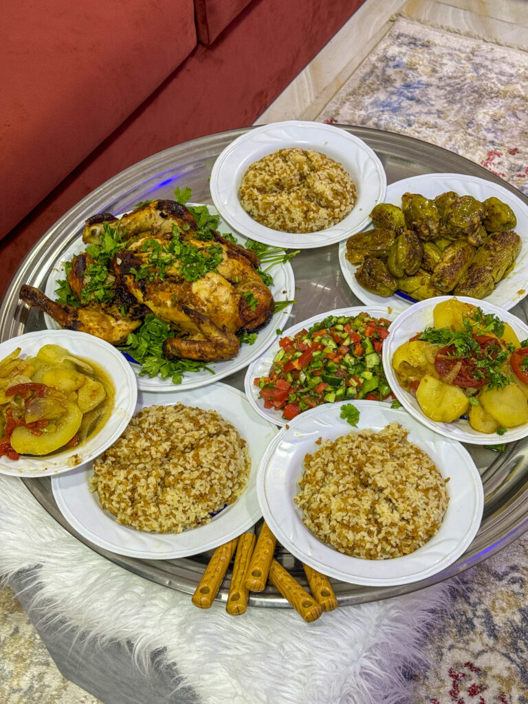 A feast of traditional Egyptian dishes, including grilled chicken, stuffed vegetables, rice, and fresh salads, served on a round tray