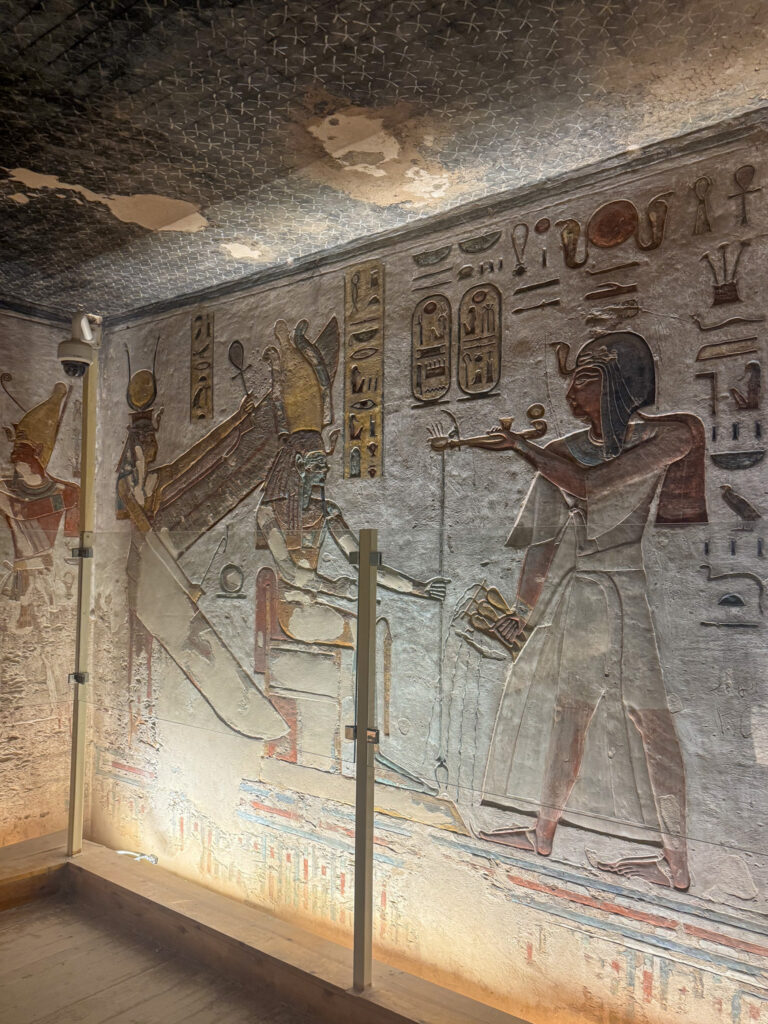 A stunning tomb painting in the Valley of the Kings, featuring a pharaoh making offerings to the gods, surrounded by hieroglyphs and intricate carvings.