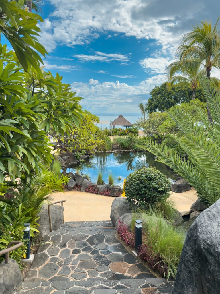 Scenic garden path through tropical plants leading to the beach at Hilton Mauritius Resort & Spa.
