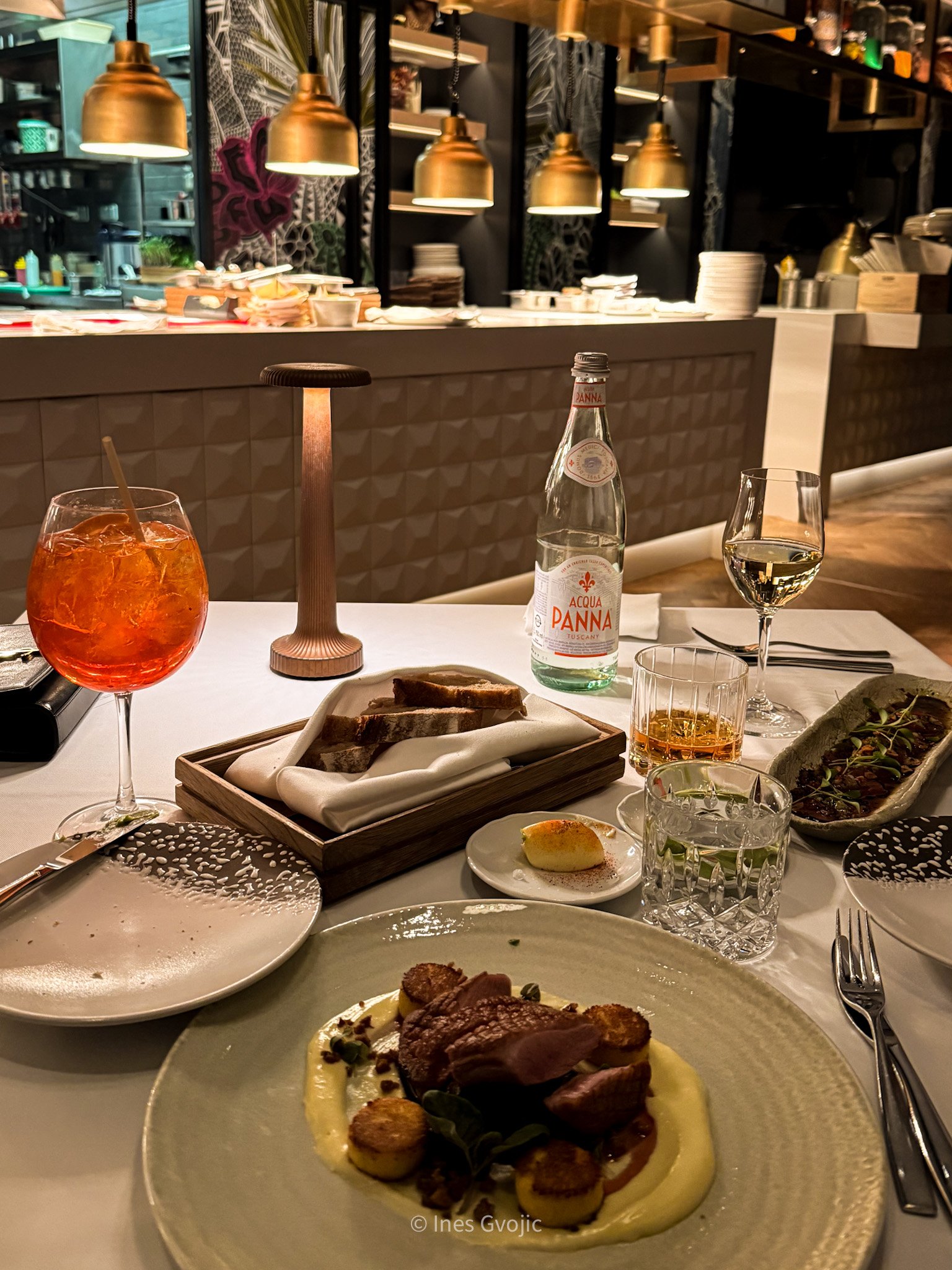 Fine dining table setup with gourmet duck dish and drinks at Spago Budapest