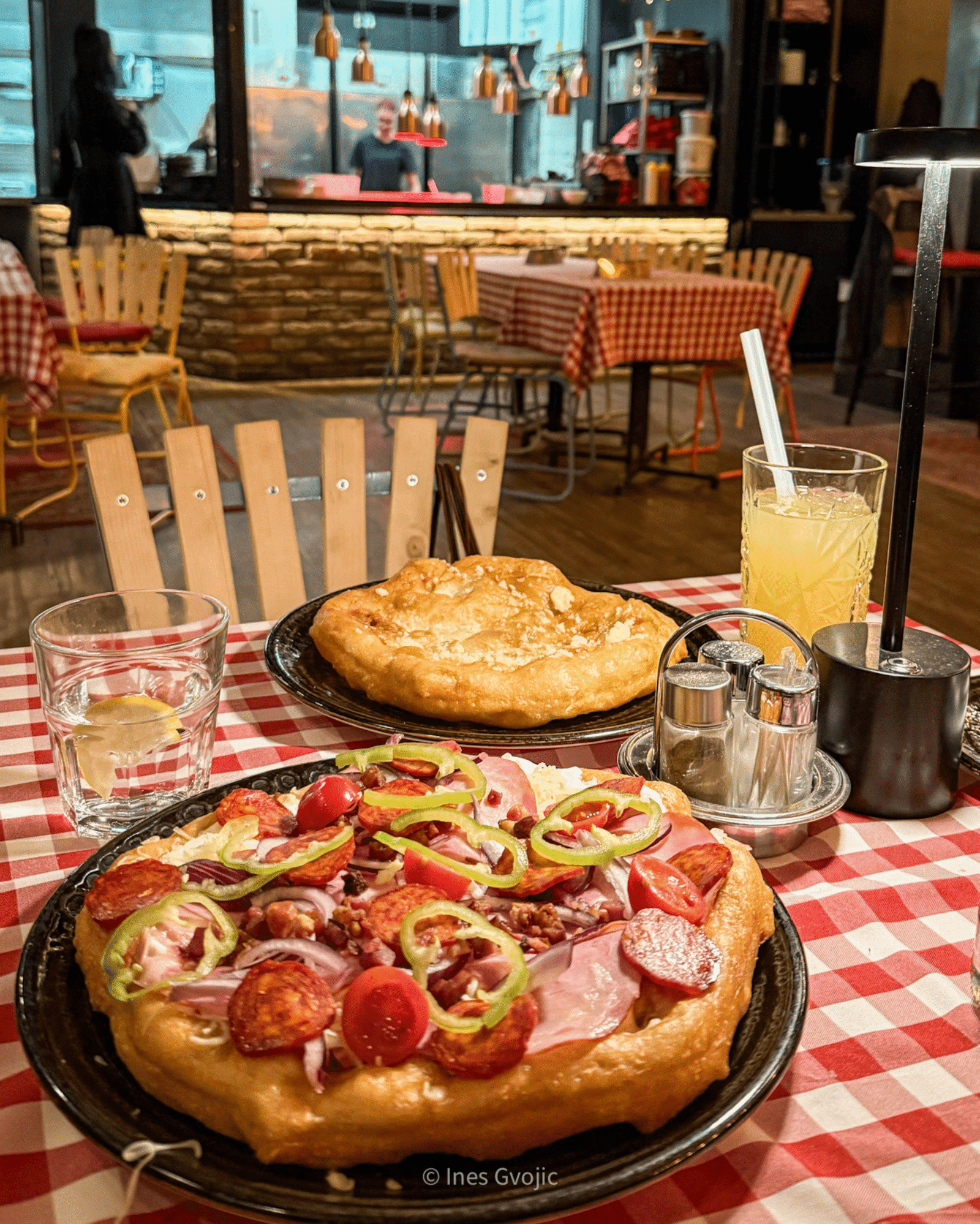 Hungarian Lángos with toppings on a checkered table at a Budapest restaurant
