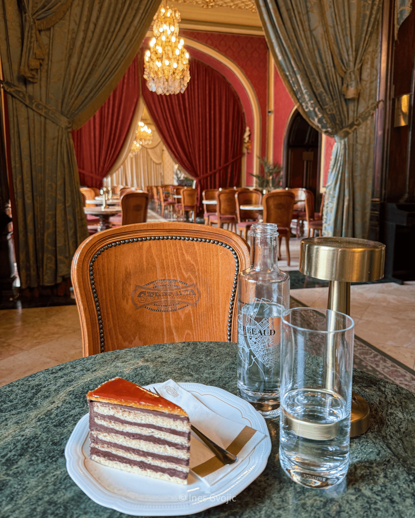 Slice of layered cake on a marble table at Gerbeaud Café in Budapest