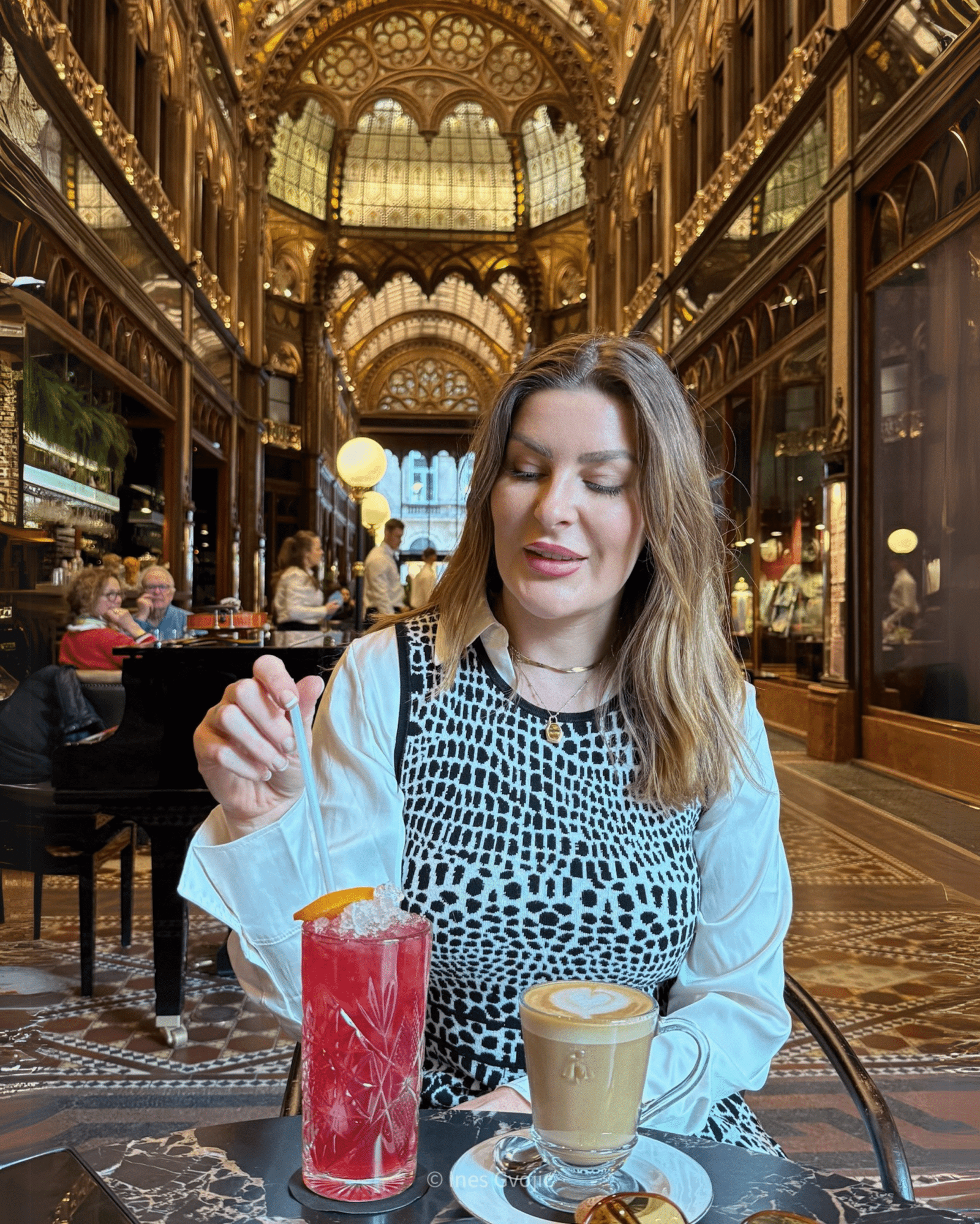 Woman enjoying drinks at Parisi Passage café in Budapest