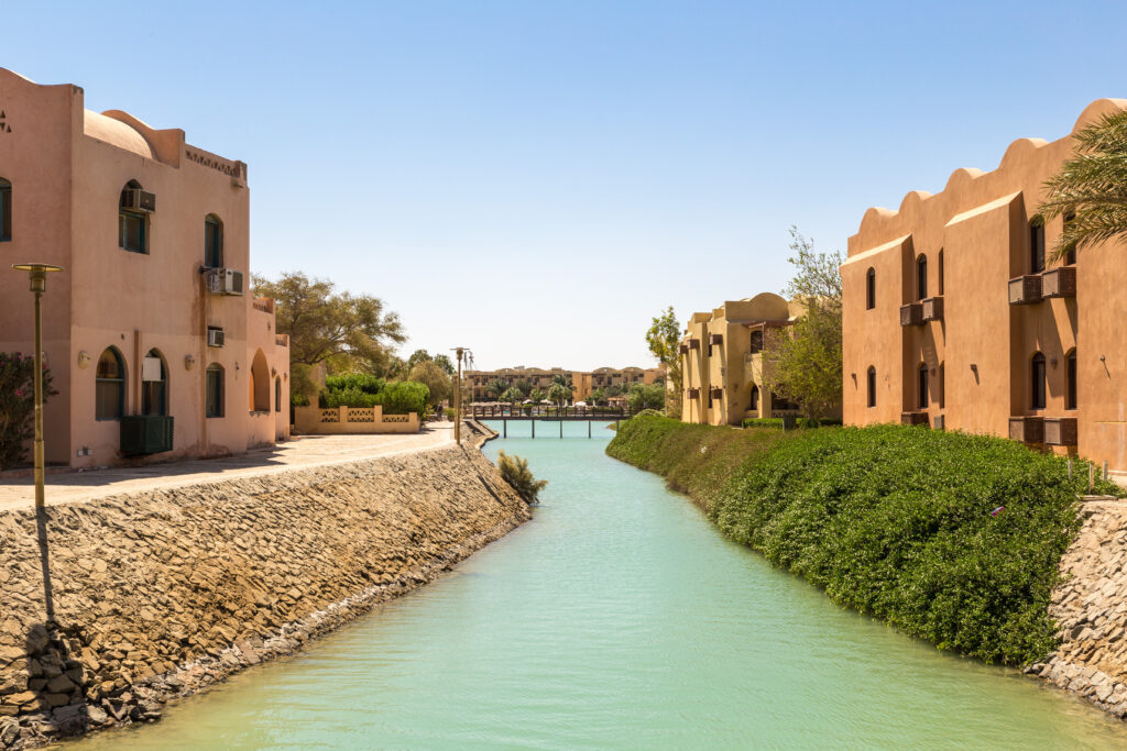 View of El Gouna resort, Egypt, North Africa — canal lined with pastel villas and palm trees on a sunny day.