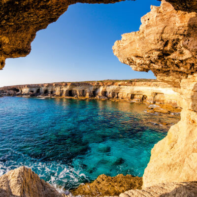 Scenic view of the sea caves in Ayia Napa, Cyprus, with crystal-clear blue waters and rugged cliffs.